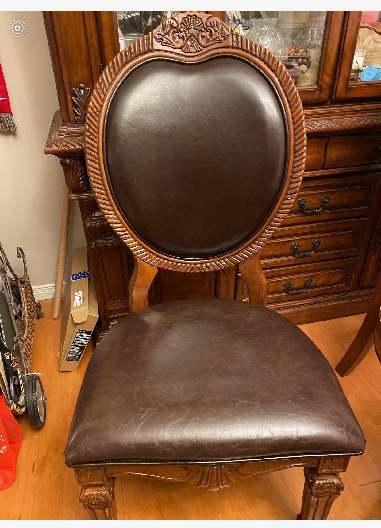 Ornate carved wood dining chair reupholstered in brown leather-look vinyl