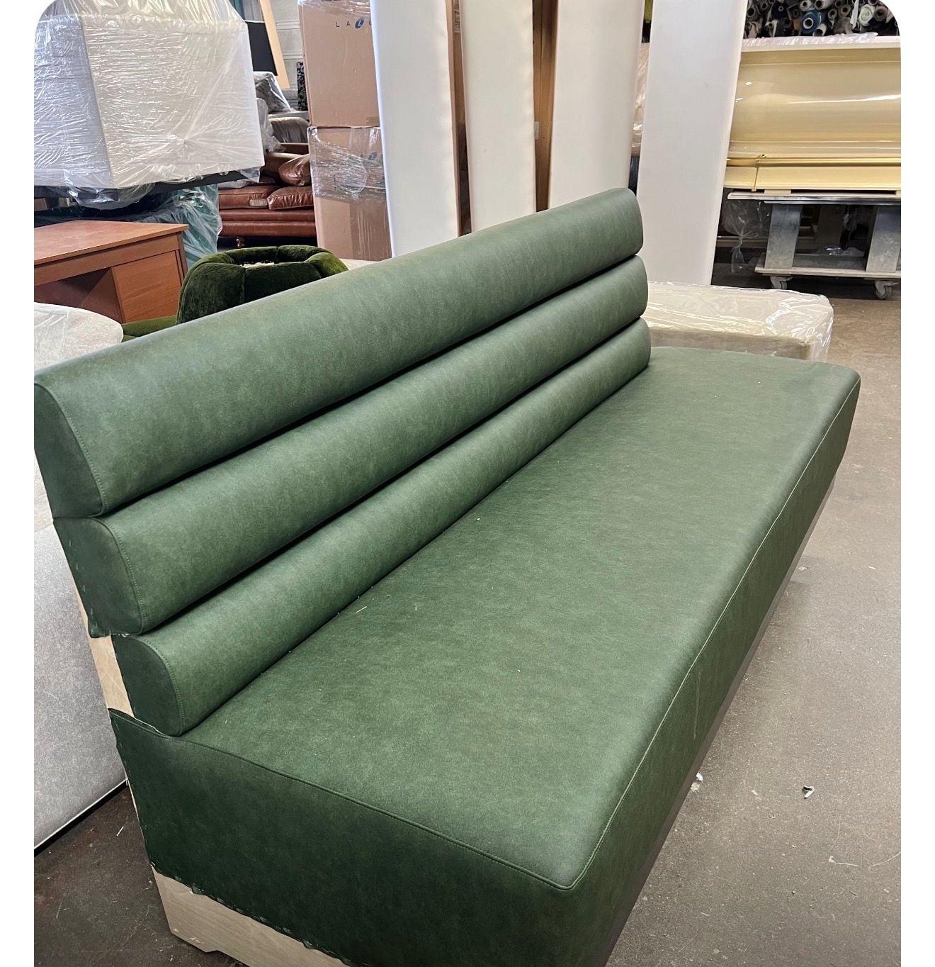 Green vinyl booth back with vertical channel tufting, photographed in the workshop
